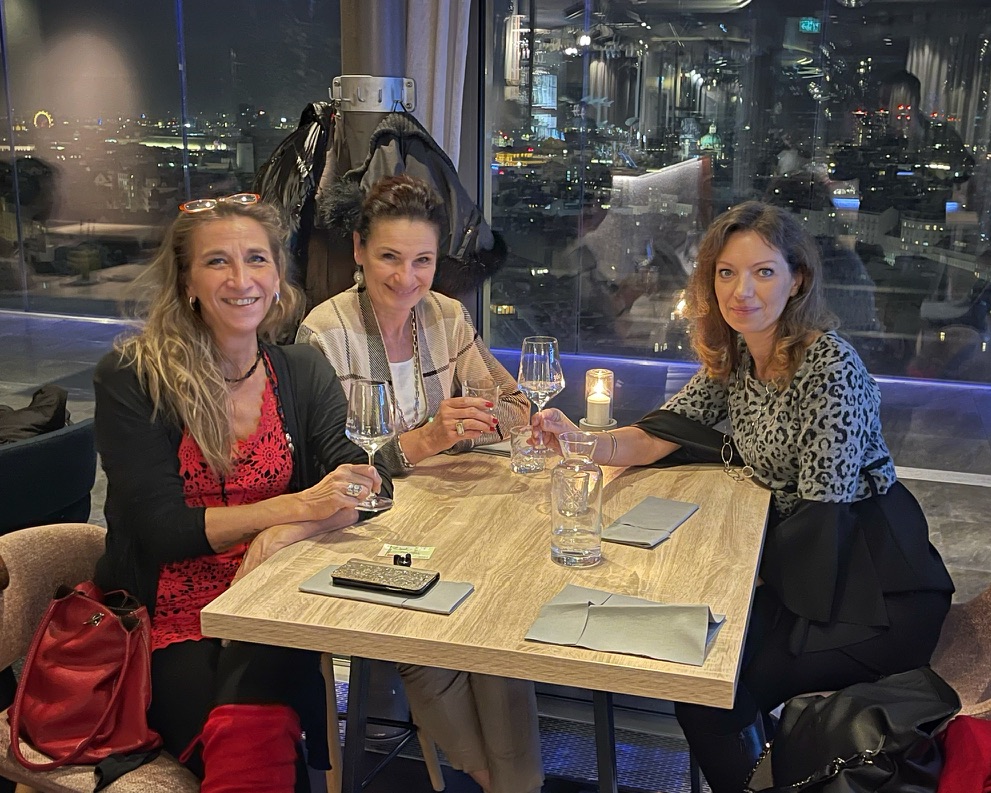 3 Frauen in einem Lokal mit einem Glas Sekt
