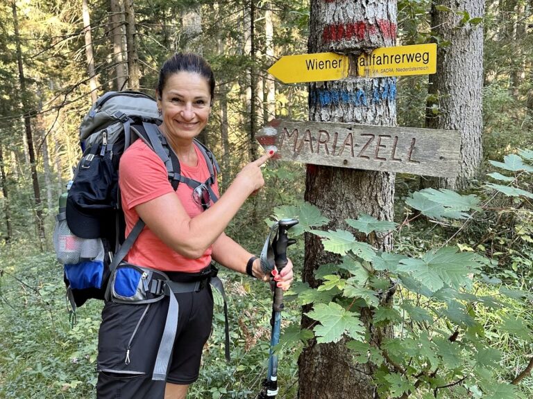 Frau vor dem Wegweiser nach Mariazell