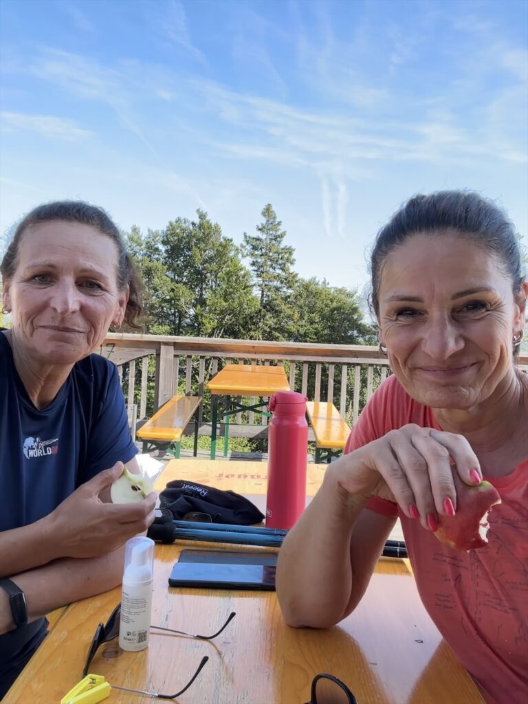 Zwei Frauen machen Pause und essen einen Apfel
