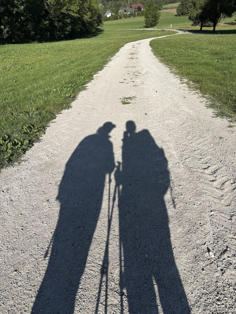 Silhouette von zwei Wanderinnen auf einem Schotterweg