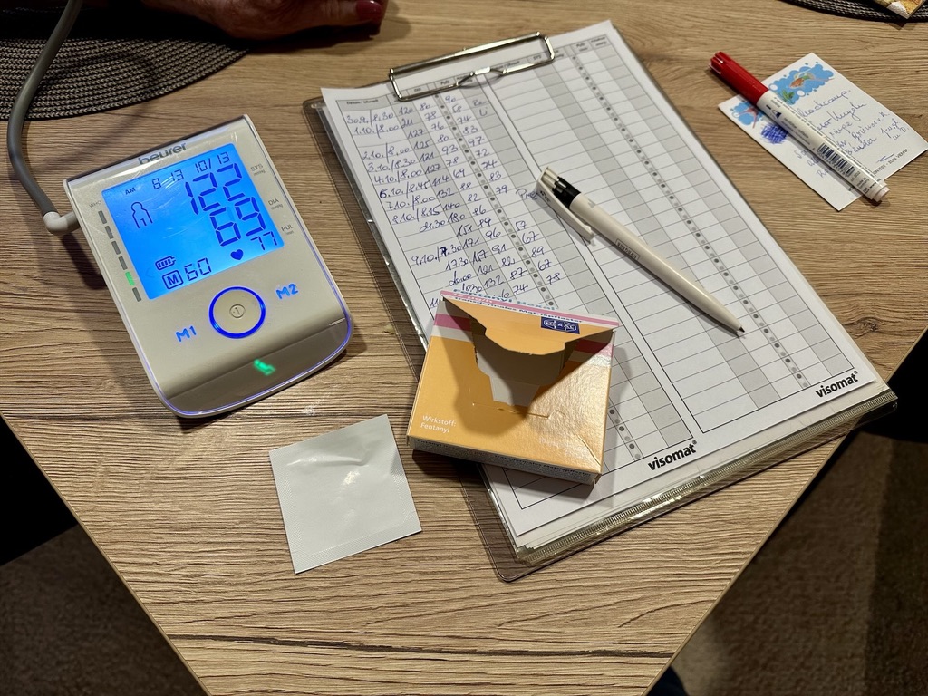 Blutdruckmessgerät und Medikamente auf einem Tisch