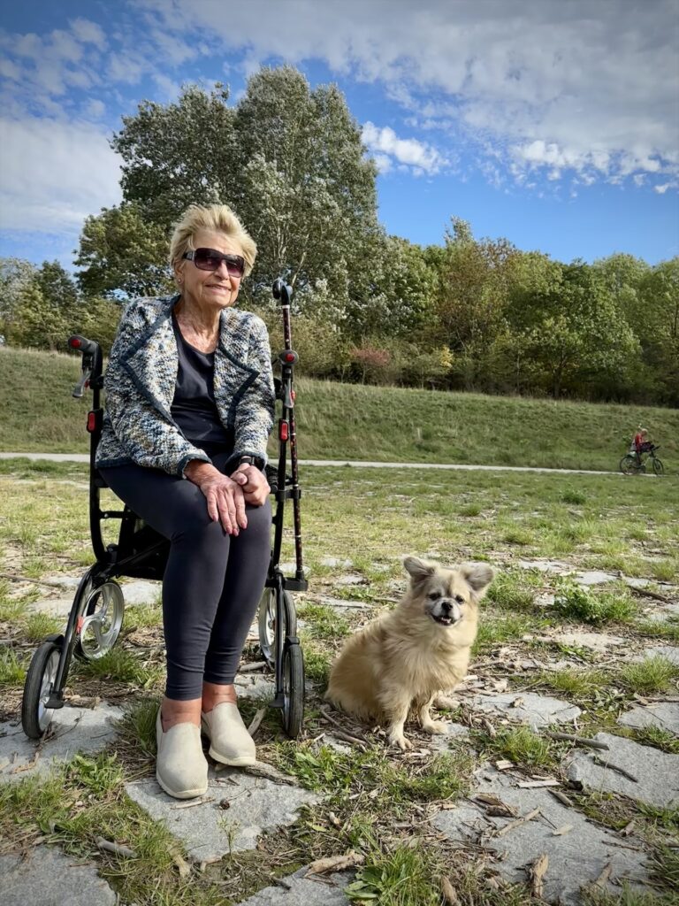 Frau und Hund sitzen in der Sonne
