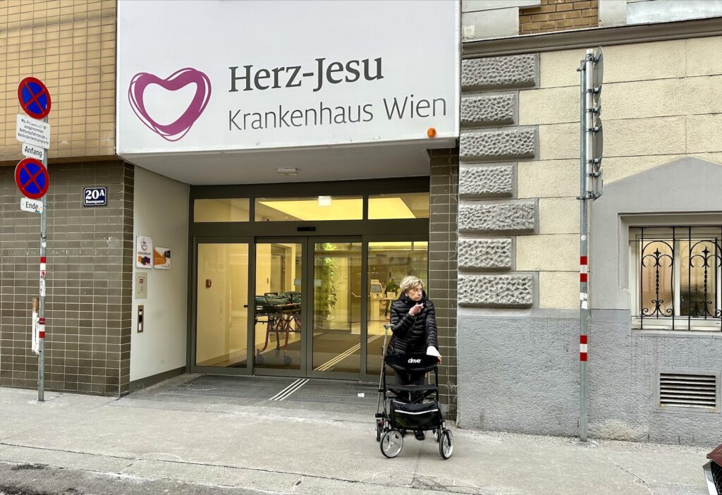 Frau wartet vor dem Krankenhaus auf ein Taxi