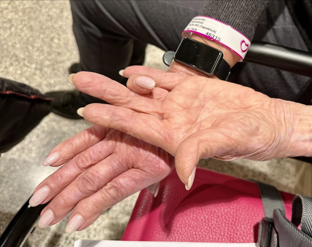 zwei Hände mit einem angewinkelten Finger vor einer Operation